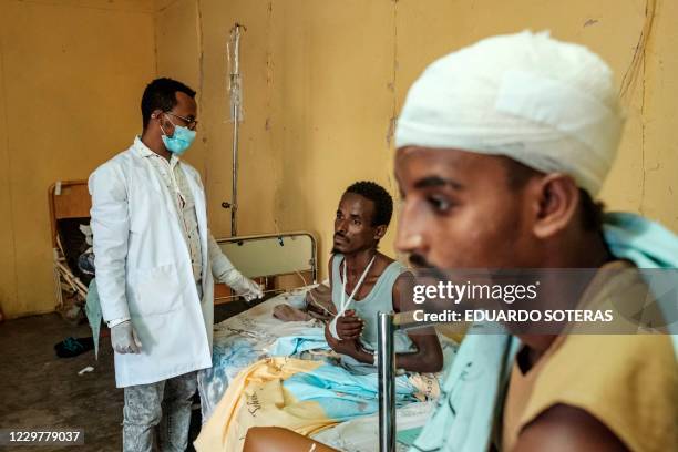 This November 20, 2020 photograph shows a survivor of the November 9, 2020 Mai Kadra massacre, being treated by a doctor at the Gondar University...