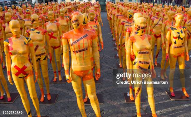 Mannequins wrapped in orange warning tape stand as a part of the installation "Broken" by the artist Dennis Josef Meneg on November 25, 2020 in Bonn,...