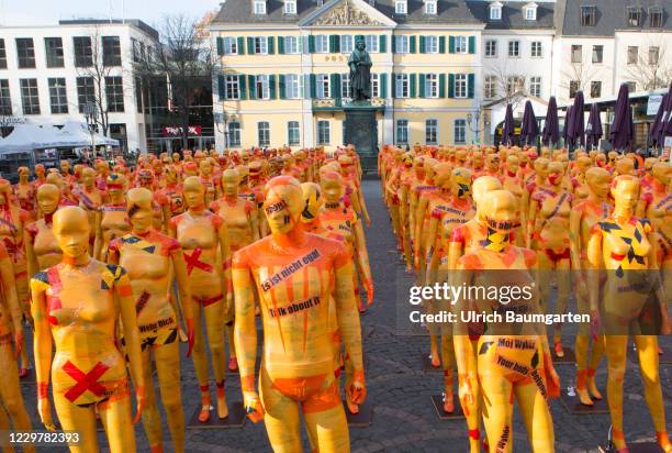 Mannequins wrapped in orange warning tape stand as a part of the installation "Broken" by the artist Dennis Josef Meneg on November 25, 2020 in Bonn,...