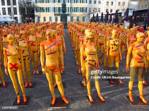 Mannequins wrapped in orange warning tape stand as a part of the installation "Broken" by the artist Dennis Josef Meneg on November 25, 2020 in Bonn,...