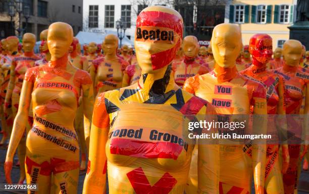 Mannequins wrapped in orange warning tape stand as a part of the installation "Broken" by the artist Dennis Josef Meneg on November 25, 2020 in Bonn,...