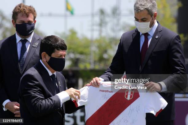 Agustin Lozano, president of Federacion Peruana de Futbol FPF, hands in a jersey of Peru's national team to President of Paraguay Mario Abdo Benitez...