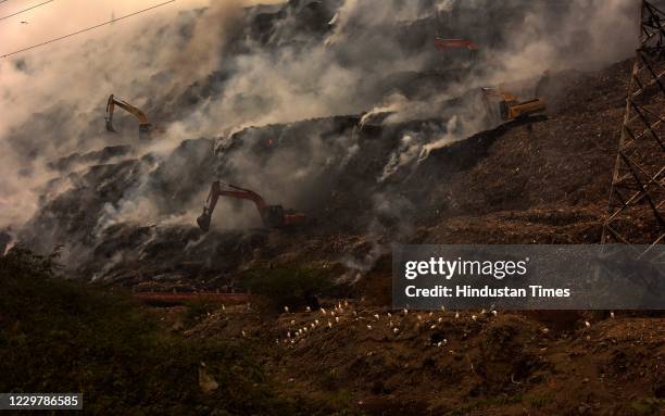 Huge plume of smoke seen rising from the waste mountain after its catch fire at the Ghazipur landfill site on November 25, 2020 in New Delhi, India.