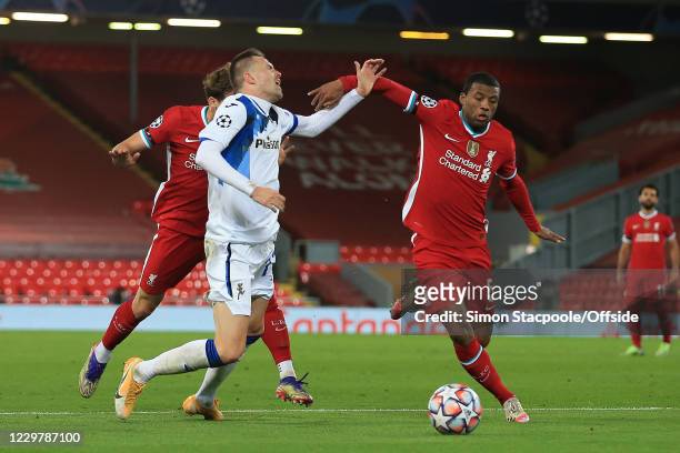 Josip Ilicic of Atalanta is brought down by Kostas Tsimikas and Georginio Wijnaldum of Liverpool but no penalty is given during the UEFA Champions...