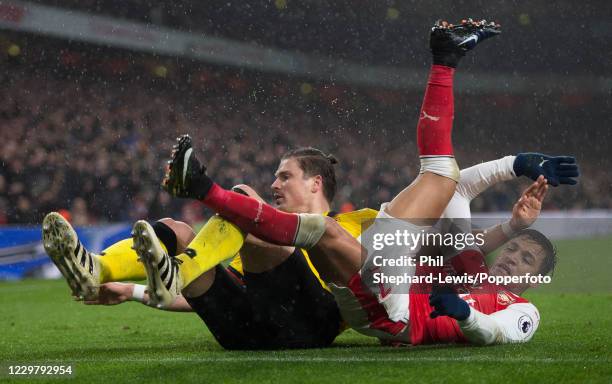 Sebastian Prodl of Watford and Alexis Sanchez of Arsenal pick themselves up after a collision during a Premier League match at the Emirates Stadium...