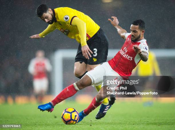 Theo Walcott of Arsenal is challenged by Miguel Britos of Watford during a Premier League match at the Emirates Stadium on January 31, 2017 in...
