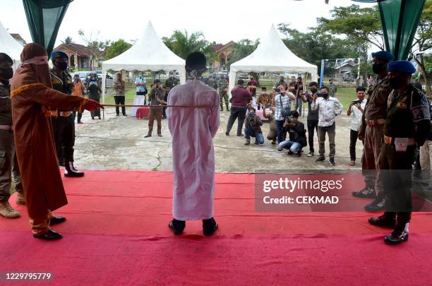 Man is publicly flogged by a member of the Sharia police after he was found guilty of raping a child, in Idi Rayeuk, East Aceh on November 26, 2020....