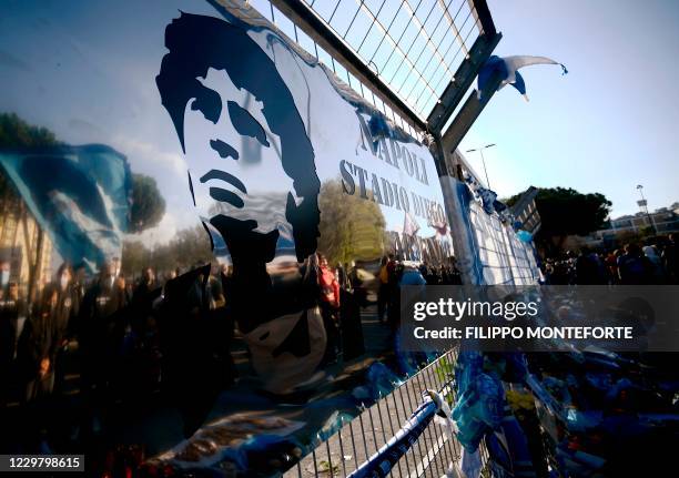 View shows a board rechristening the stadium to "Diego Armando Maradona stadium", as people gather on November 26, 2020 outside the San Paolo stadium...