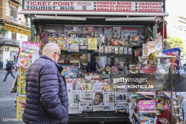 Man at a newsstand looks at the front pages featuring the death of football legend Diego Armando Maradona, who played for SSC Napoli in the eighties....