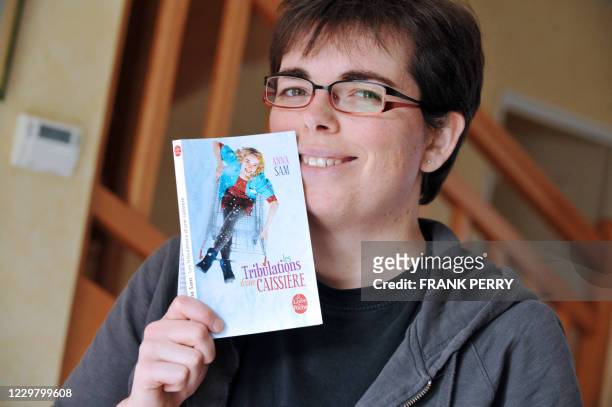 Anna Sam, ancienne caissière dans la grande distribution, pose le 06 décembre 2011 à son domicile de l'Hermitage, près de Rennes, avec son livre "Les...