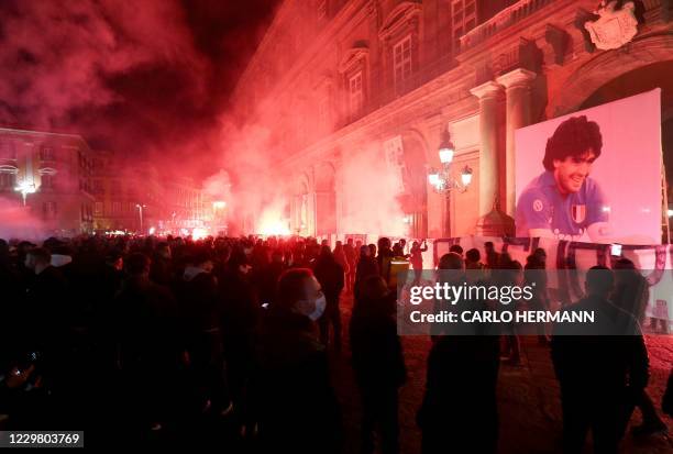 Torches are lit on Piazza del Plebiscito in Naples on November 26, 2020 as people gather to mourn the death of late Argentinian football legend Diego...