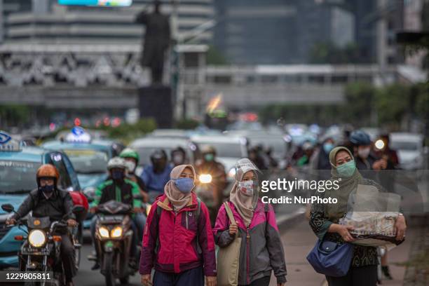 People wear protective face mask walk in Central Business District in Jakarta on Thursday 26 November 2020. Indonesia has recorded over half million...