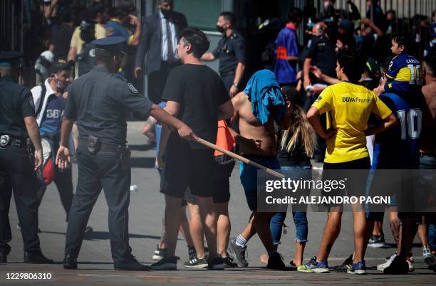 Fans of late Argentinian football legend Diego Armando Maradona stands outside the Casa Rosada government house where Maradona's wake took place, in...