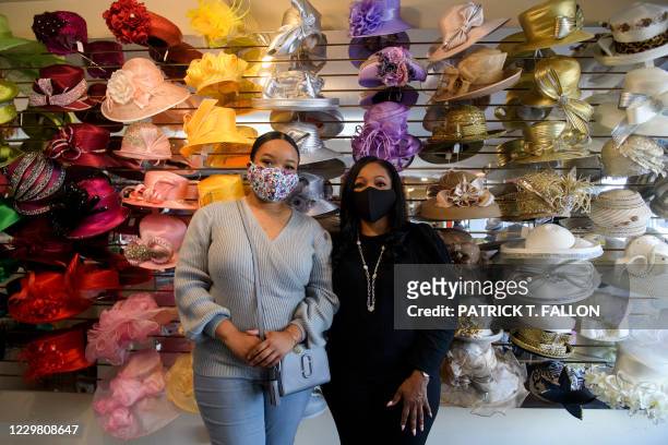 Meeka Robinson Davis, owner of One-Of-A-Kind Hats and daughter Chrstiana Davis stand for a portrait with some of the hats at their store in the...