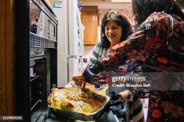 Virginia Bautista and her daughter Rosa Broughton prepare a turkey for a family gathering on November 26, 2020 in Los Angeles, California. Families...