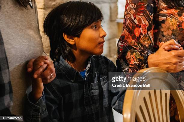 Gonzalo Bautista prays with his family during a gathering on November 26, 2020 in Los Angeles, California. Families have adjusted plans under CDC...