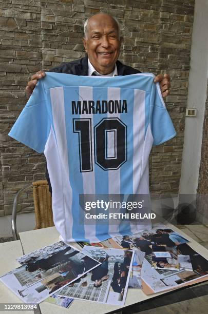 Tunisian referee Ali Bin Nasser poses at home in the capital Tunis on November 27 with the shirt given to him by Diego Armando Maradona when he...