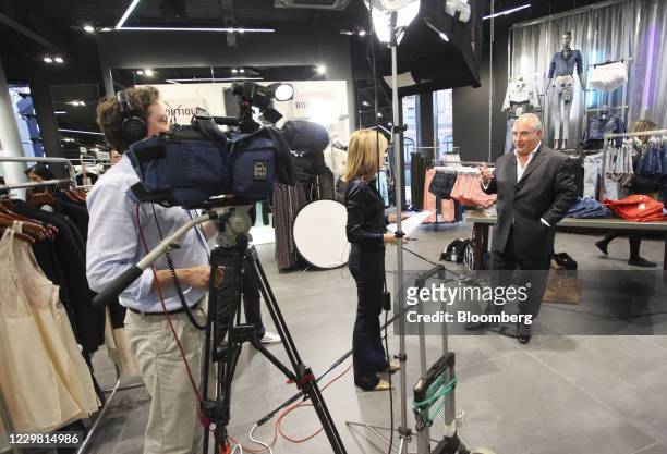 Philip Green, the billionaire owner of Arcadia Group Ltd., right, speaks during a television interview at his new Topshop store in London, U.K., on...