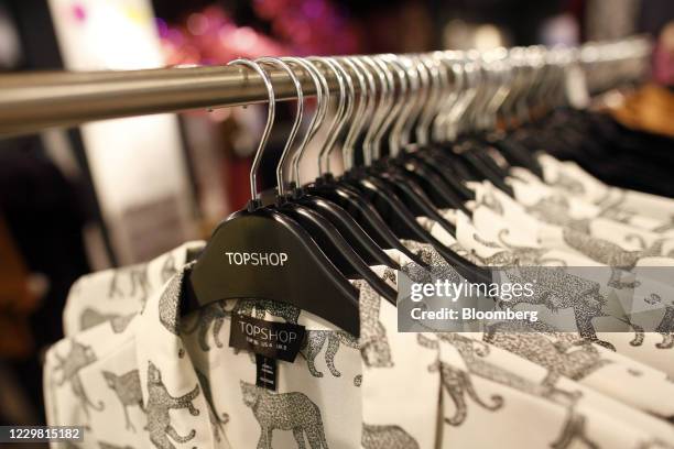 Women's clothes hang on branded-hangers inside a Topshop store, owned by Arcadia Group Ltd., on Oxford Street in London, U.K., on Thursday, Dec. 6,...