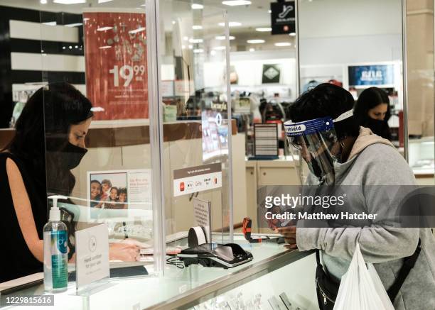 Black Friday shoppers in masks and PPE make the rounds to different stores at the Franklin Park Mall looking for Black Friday deals on November 27,...