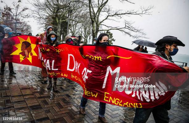 Demonstrators march through the rain to Plymouth Rock while participating in the 50th Anniversary of The National Day of Mourning, a reminder of the...