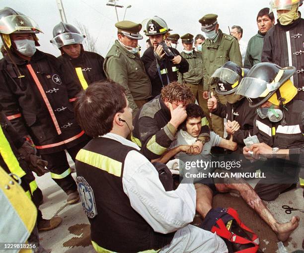 Firefighter is helped by paramedics after suffering burns from helping to put out a fire 17 August 1999. Un bombero es atendido por paramedicos tras...