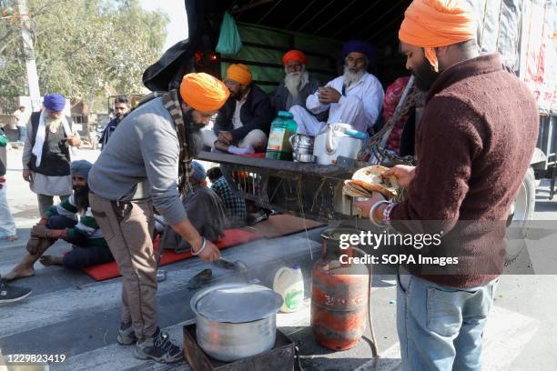 Protesters preparing food after police forces stopped them from marching towards New Delhi during the demonstration. Groups of farmers marched from...