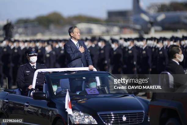 Japanese Prime Minister Yoshihide Suga reviews the Japan Air Self-Defense Force at the Air Self-Defense Force's Iruma base in Sayama, Saitama...
