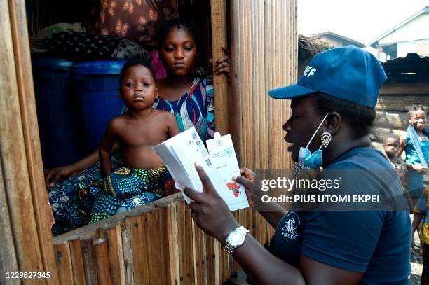 Bidemi Aye receives a pre-paid debt card for cash and food provided by World Food Programme in a makeshift home in the Makoko riverine slum...