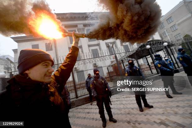 Ukrainian far-right activists burn smog bombs outside Russian embassy in Kiev on November 28, 2020 during their protest action called "You killed us...