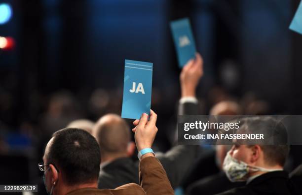 Delegates hold up their voting cards during the Party Congress of farright AfD party at the Wunderland Kalkar, western Germany, on November 28, 2020.