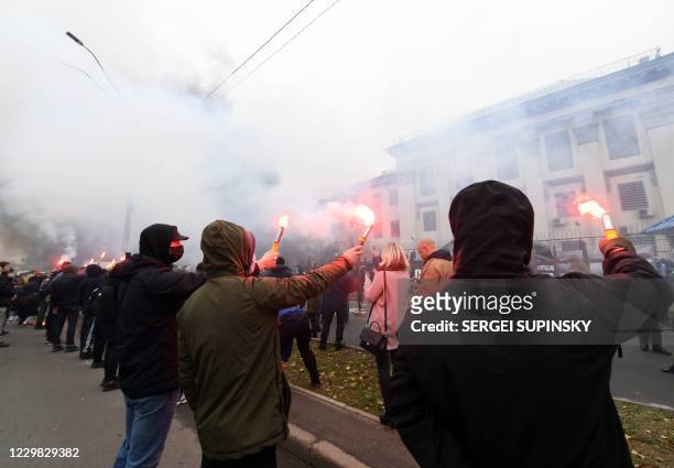 Ukrainian far-right activists burn smog bombs outside Russian embassy in Kiev on November 28, 2020 during their protest action called "You killed us...