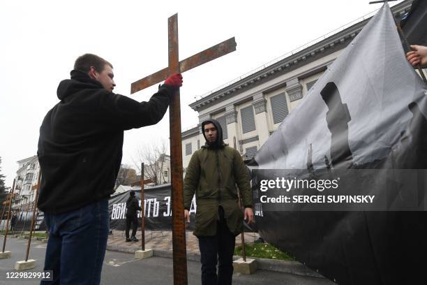 Ukrainian far-right activists set symbolic crosses outside Russian embassy in Kiev on November 28, 2020 during their protest action called "You...