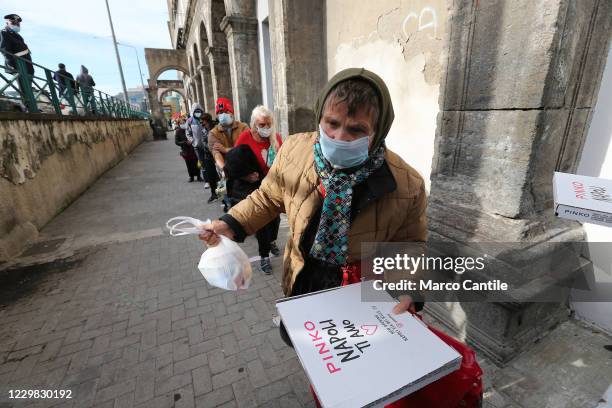 People queuing in front of the Caritas in Carmine square in Naples, while they receive a meal and pizza, during the Pizza Solidale initiative, the...