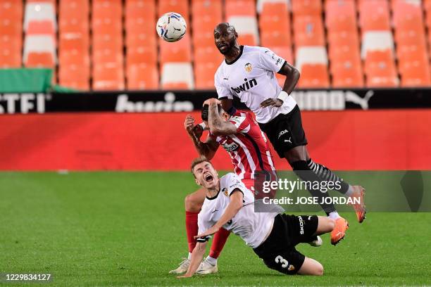 Valencia's French defender Eliaquim Mangala and Valencia's Spanish defender Toni Lato vie with Atletico Madrid's Spanish midfielder Vitolo during the...