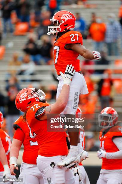 Running back Dezmon Jackson of the Oklahoma State Cowboys celebrates a touchdown with guard Josh Sills against the Texas Tech Red Raiders in the...