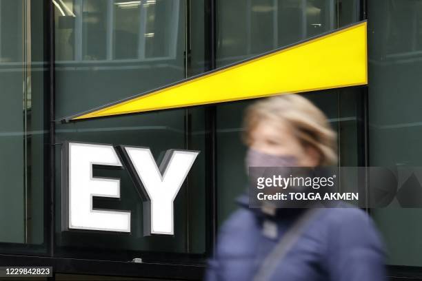 Pedestrians walk past the offices of accounting and auditing firm EY, formerly Ernst & Young, in London on November 20, 2020. - Britain's audit...