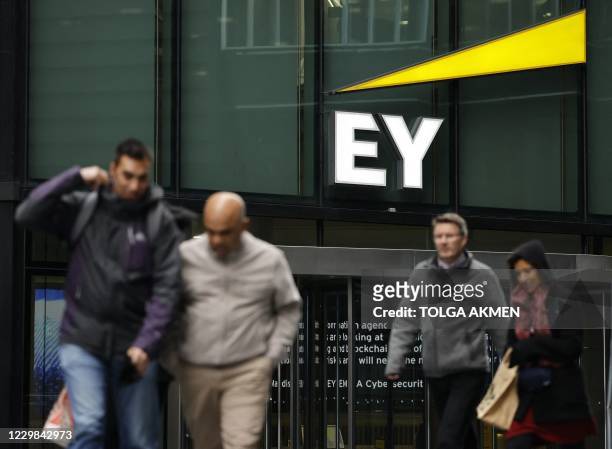 Pedestrians walk past the offices of accounting and auditing firm EY, formerly Ernst & Young, in London on November 20, 2020. - Britain's audit...