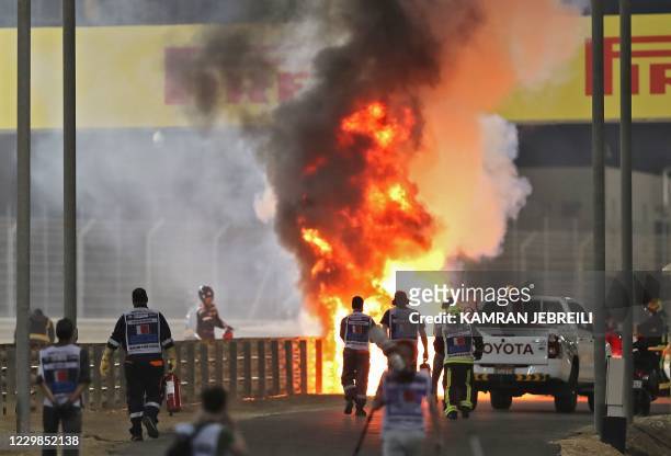 Haas F1's French driver Romain Grosjean's car burns after crashing during the Bahrain Formula One Grand Prix at the Bahrain International Circuit in...