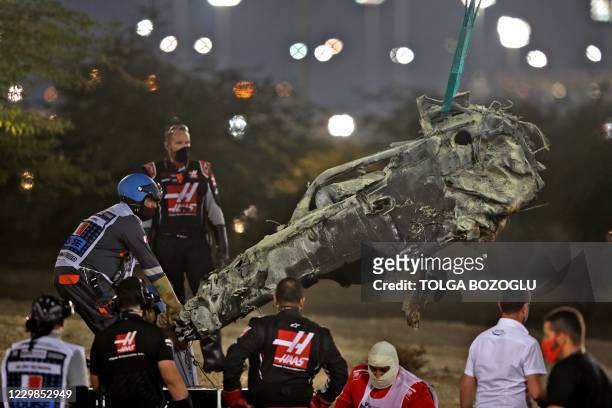 The suvival cell of Haas F1's French driver Romain Grosjean's car is removed after a crash during the start of the Bahrain Formula One Grand Prix at...