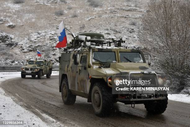 Military vehicles of the Russian peacekeeping force move on the road outside Lachin on November 29 after six weeks of fighting between Armenia and...