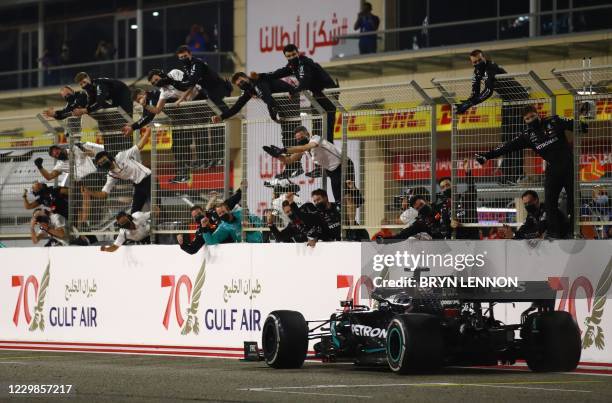 Mercedes' British driver Lewis Hamilton is congratulated by his pit crew after winning the Bahrain Formula One Grand Prix at the Bahrain...