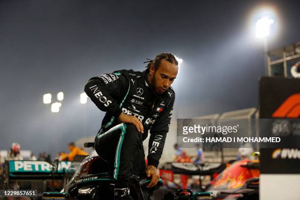 Mercedes' British driver Lewis Hamilton steps out of his car after winning the Bahrain Formula One Grand Prix at the Bahrain International Circuit in...