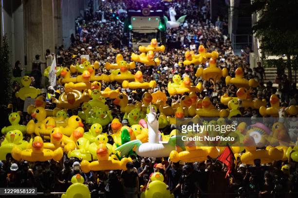 Pro-democracy protesters carry inflatable rubber ducks during a march toward the 11th Infantry Regiment in Bangkok to calling the prime minister to...