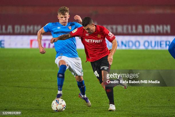 Dani Rodriguez of RCD Mallorca and Mateusz Bogusz of UD Logrones competes for the ball at Estadi de Son Moix on November 29, 2020 in Mallorca, Spain.