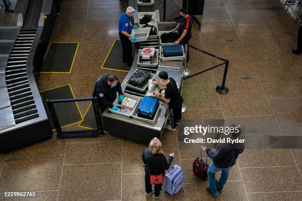 Travelers pass through security screening at Seattle-Tacoma International Airport on November 29, 2020 in SeaTac, Washington. Public health experts...