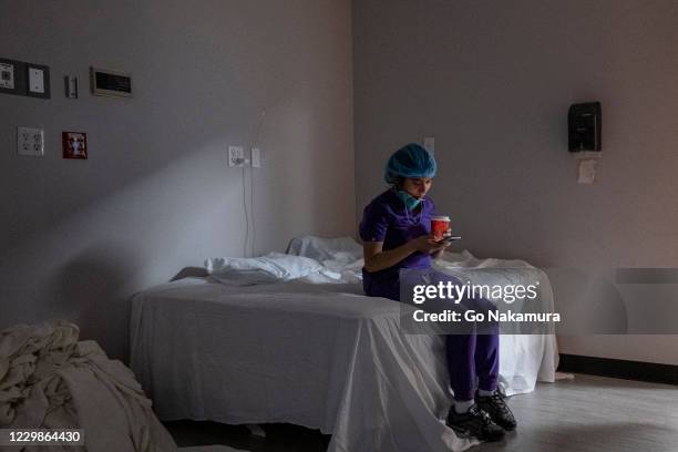 Medical staffer Anne Aguilar checks her phone during a break from the COVID-19 intensive care unit at the United Memorial Medical Center on November...