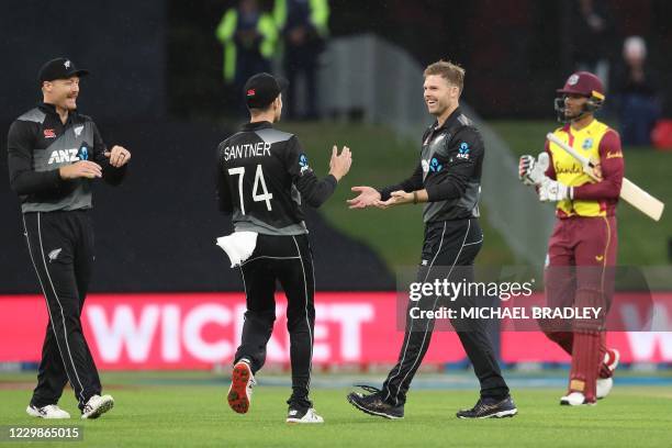 New Zealands Lockie Ferguson celebrates with Mitchell Santner and Martin Guptill for the wicket of West Indies' Brandon King during the third...