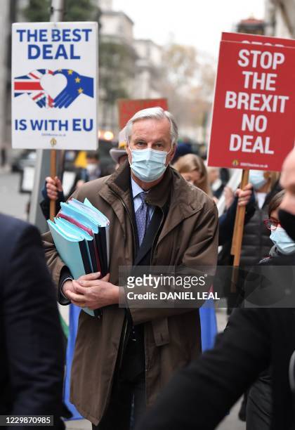 An Anti-Brexit demonstrator hold placards as EU chief negotiator Michel Barnier , wearing a protective face covering to combat the spread of the...