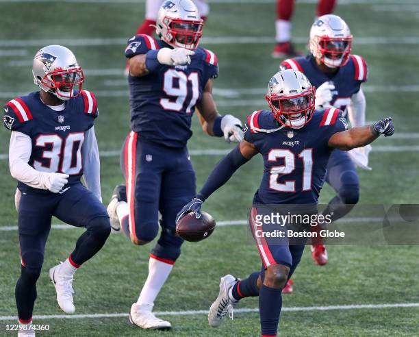 After he intercepted a third quarter pass on a ball tipped by DL Adam Butler , Patriots DB Adrian Phillips celebrated with teammates Jason McCourty ,...